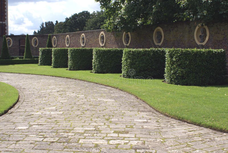 Garden wall, statues, topiary, and pathway