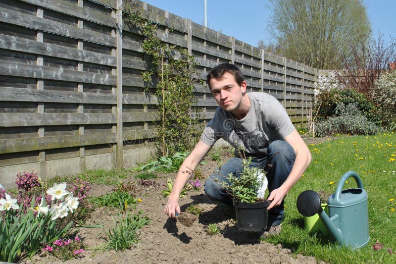 Giovane uomo che lavora nel giardino di primavera.