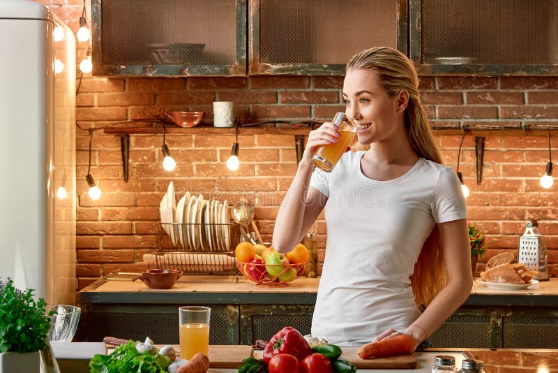 Gardez le calme mangent des fruits plus des légumes Jeune femme heureuse faisant cuire des légumes dans la cuisine moderne Intéri images stock Gardez le calme mangent des fruits plus des légumes Jeune femme heureuse faisant cuire des légumes dans la cuisine moderne Intéri images stock
