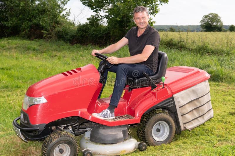 Gardner man on ride-on lawn mower gardener in garden stock photo Gardner man on ride-on lawn mower gardener in garden stock photo