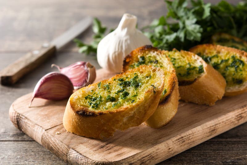 Garlic Breads Slice and Ingredients on Wooden Table. Stock Photo