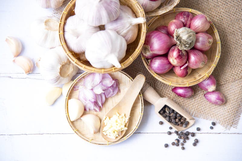 Garlic,shallot,Black pepper, fresh garlic, garlic clove, garlic bulb and Onion in a wooden basket on white wooden table, A herb