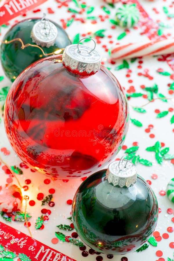 Garnering med den röd vätska fyllda julprydnadbollen och två gör grön fyllda prydnadbollar som omges av ett rött, har själv A M. royaltyfri bild Garnering med den röd vätska fyllda julprydnadbollen och två gör grön fyllda prydnadbollar som omges av ett rött, har själv A M. royaltyfri bild