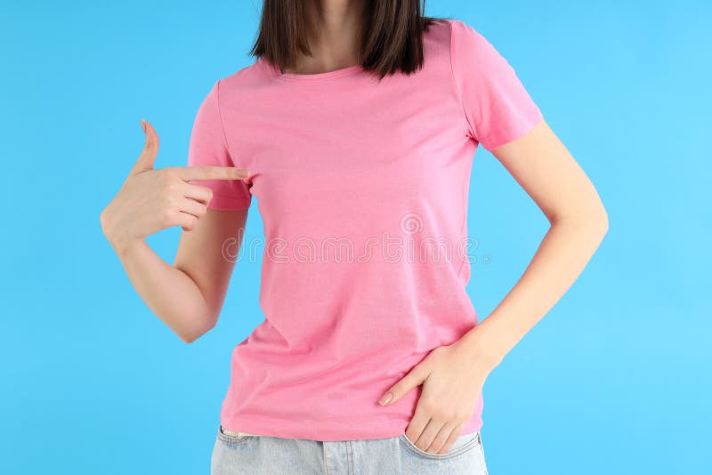 Garota atraente em camisa rosa com fundo azul fotografia de stock royalty free