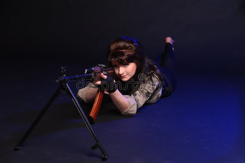 Rapariga com armas num fundo escuro no estúdio fotografia de stock