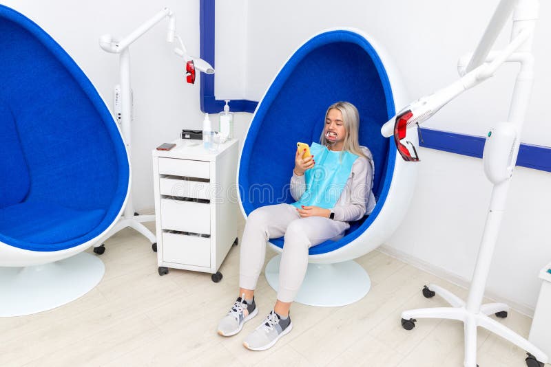 Garota com bonés dentárias sentada em um salão de beleza foto de stock Garota com bonés dentárias sentada em um salão de beleza foto de stock