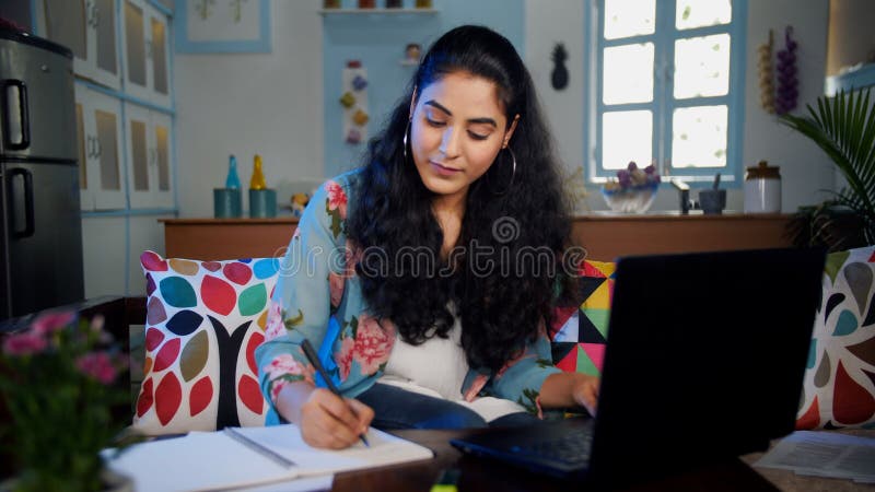 Garota confiante que está fazendo collegeging tirando anotações de um aprendizado remoto de laptop