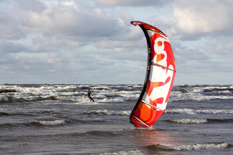 Brave girl skillfully copes with sail and big waves with a fair wind. Brave girl skillfully copes with sail and big waves with a fair wind