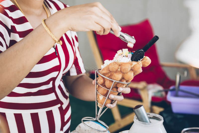 A garota está preparando uma sobremesa deliciosa Gelado de Hong Kong Coloca marmelada com pinças no topo foto de stock A garota está preparando uma sobremesa deliciosa Gelado de Hong Kong Coloca marmelada com pinças no topo foto de stock