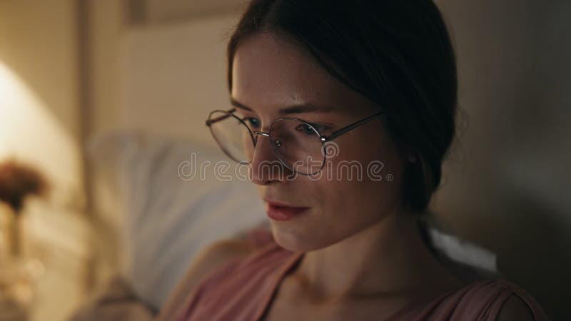 Garota focada em close trabalhando em casa à noite. mulher gráelancer séria de óculos