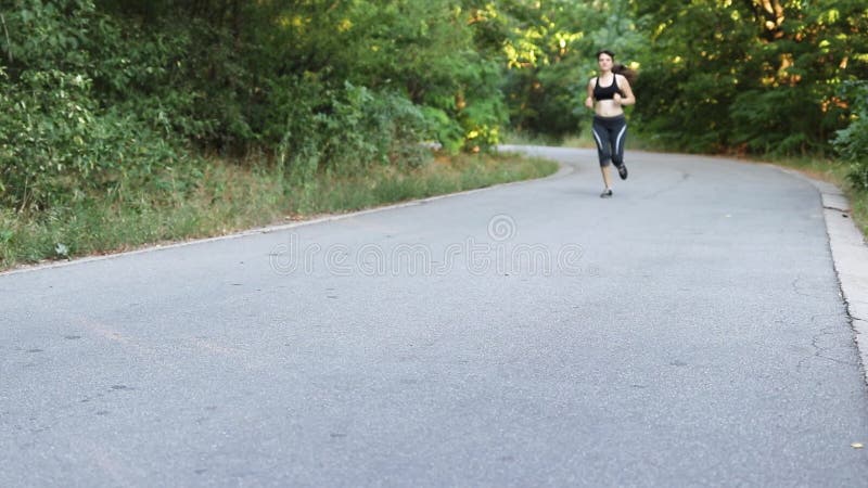 Um homem correndo em um caminho na floresta