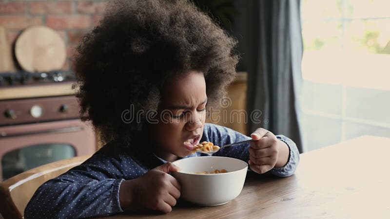 Garotinha africana comendo flocos de milho com leite fechado