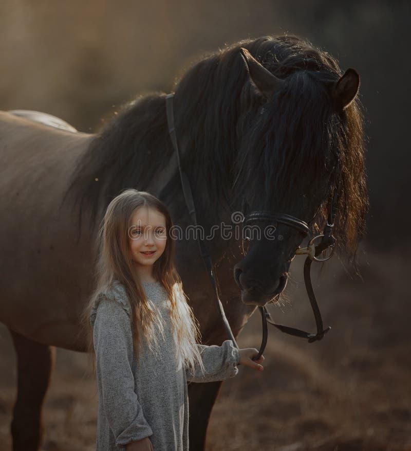 Garotinha de cabelos compridos no estilo casual com cavalo marrom fotos de stock