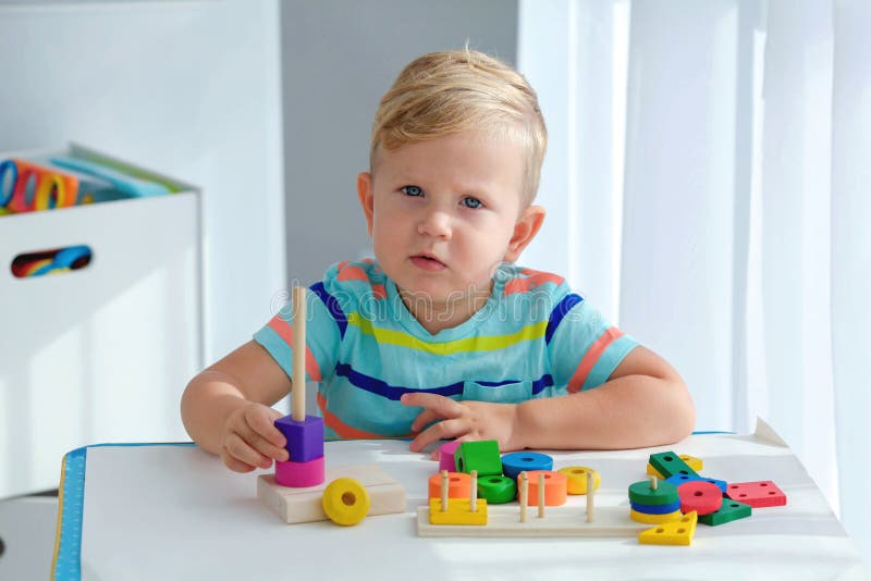 Garotinho De 2 Anos é Tocado Com Uma Pirâmide De Madeira. Brinquedos  Lógicos Educativos Para Crianças. Jogos Montessori Para Crian Foto de Stock  - Imagem de eduque, jogo: 201508416