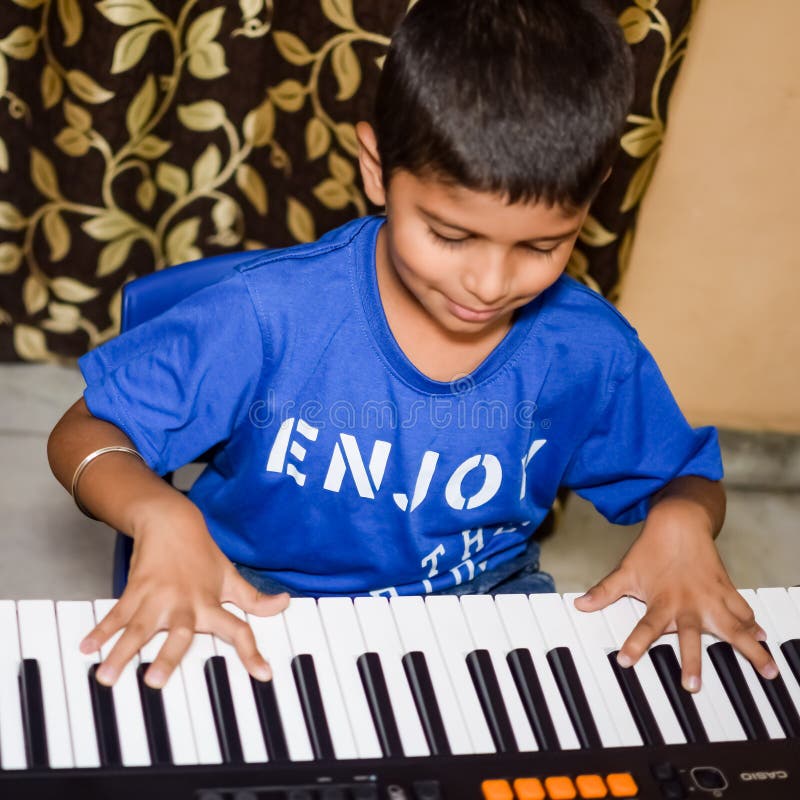 Criança asiática aprendendo a tocar piano online em casa