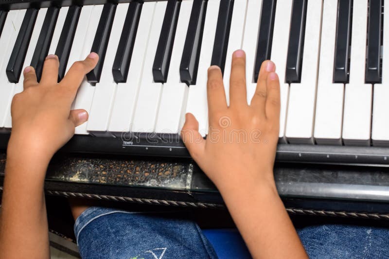 Criança asiática aprendendo a tocar piano online em casa