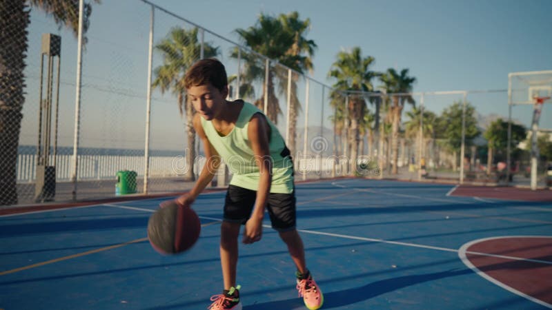 Esportivo com bola para jogar basquete, ouvindo música em fones de ouvido  no parquinho do campo