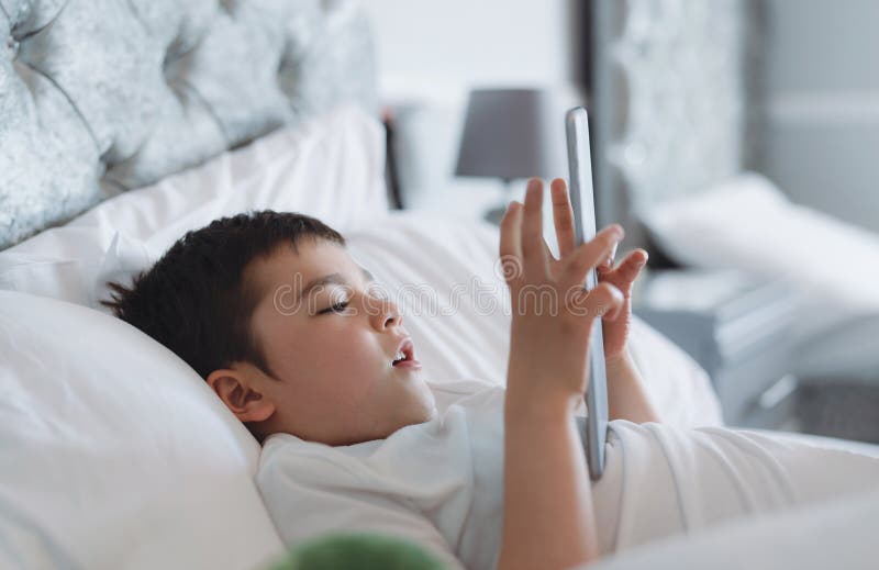 Foto de Feliz Sorrindo Menino Alegre Assistindo Desenhos Animados E Jogando  Jogos No Tablet Computador À Noite Conceito De Educação Infantil E Estudo À  Noite e mais fotos de stock de Criança 