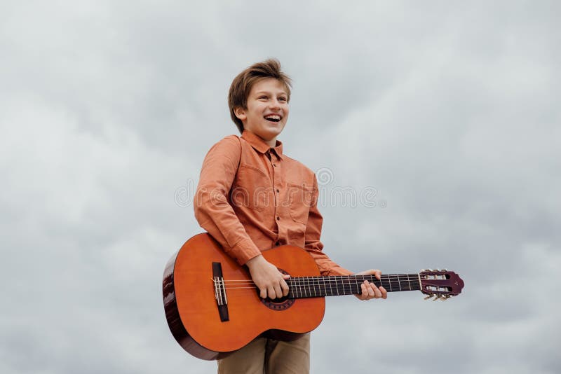 Menino Roqueiro Com Guitarra Foto de Stock - Imagem de vestido