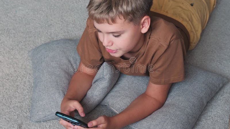 retrato cinematográfico menino jogando no celular enquanto espera por  comida, garoto sentado no café enviando texto para amigos, criança jogando jogo  online no telefone. 9713796 Foto de stock no Vecteezy