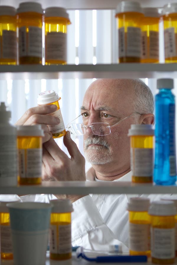 Garrafa da prescrição da leitura do homem superior fotografia de stock Garrafa da prescrição da leitura do homem superior fotografia de stock