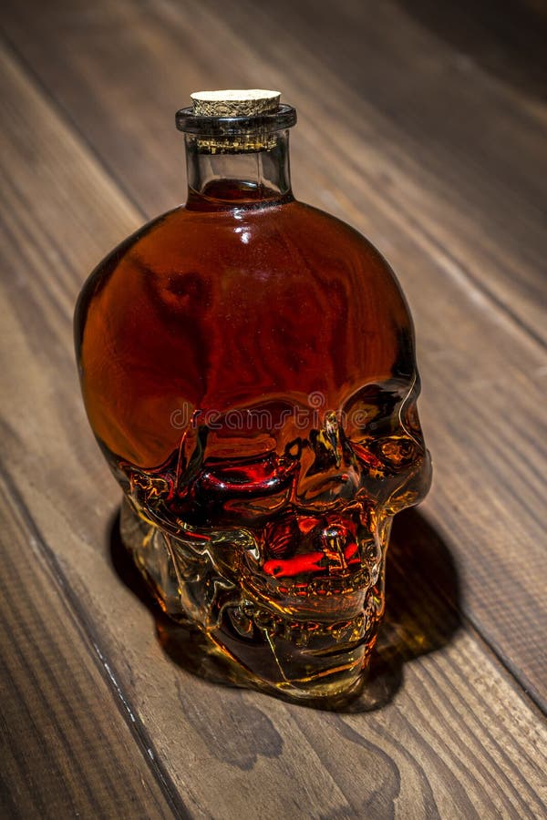 Garrafa na forma de um crânio com álcool O conceito do dano do álcool alcoholism imagens de stock Garrafa na forma de um crânio com álcool O conceito do dano do álcool alcoholism imagens de stock