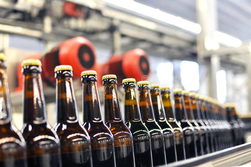 Garrafas de cerveja na linha de montagem de uma usina moderna - usina industrial na indústria alimentícia
