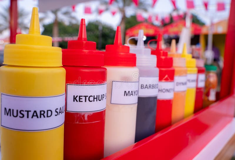 Multiple flavor sauce bottles in a food card at a food festival ready to be used. Multiple flavor sauce bottles in a food card at a food festival ready to be used
