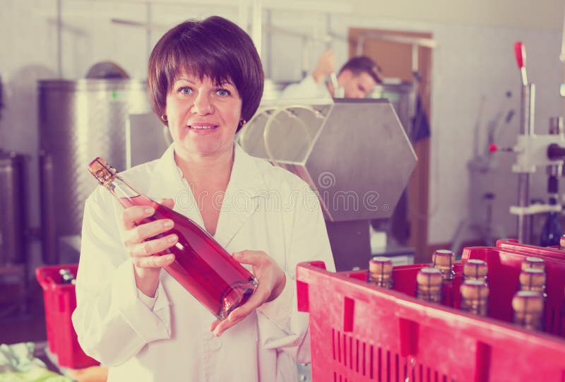 Garrafas de vinho fêmeas positivas da embalagem do empregado imagens de stock Garrafas de vinho fêmeas positivas da embalagem do empregado imagens de stock