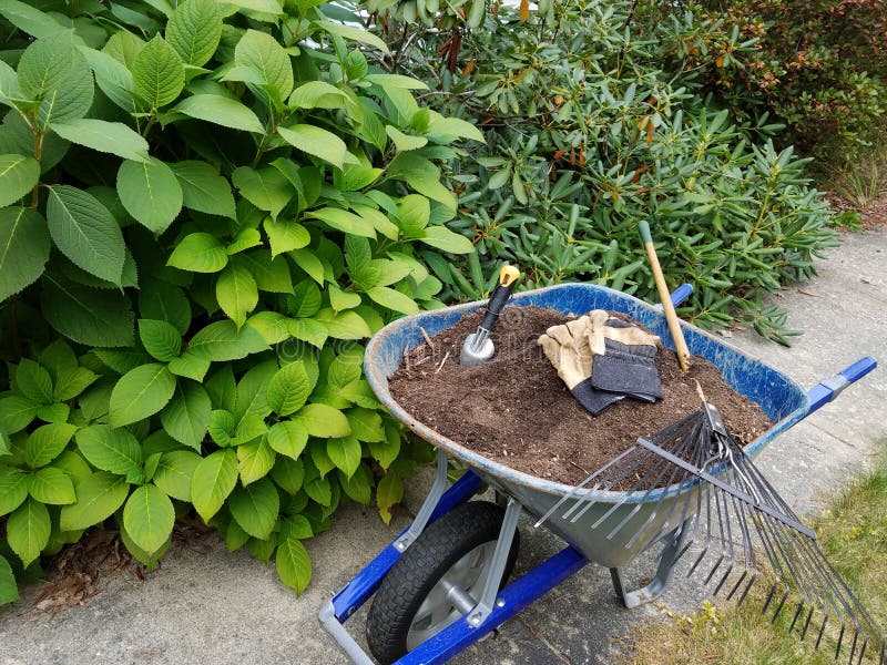 Gartenarbeit- und Yardarbeit - Schubkarre und Rührstange