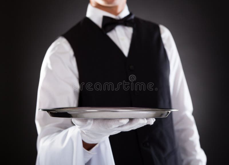 Garçom masculino que guarda a bandeja imagens de stock Garçom masculino que guarda a bandeja imagens de stock
