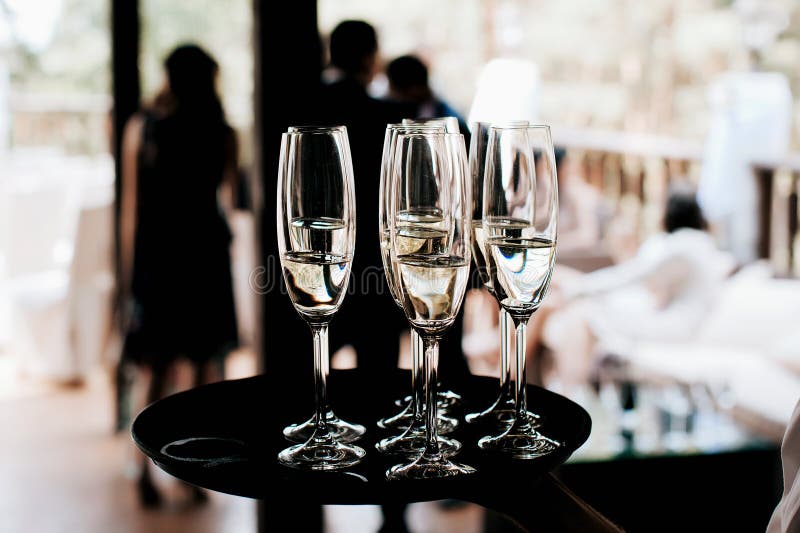 Garçom traz óculos cheios de champanhe em uma bandeja imagem de stock