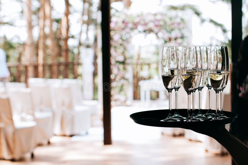 Garçom traz óculos cheios de champanhe em uma bandeja foto de stock