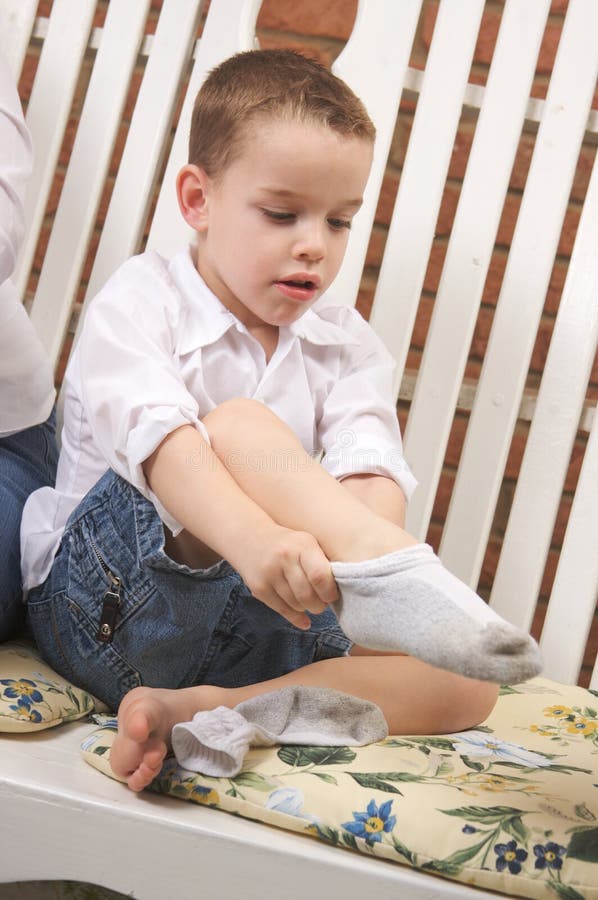 Garçon adorable obtenant des chaussettes jeunes image stock