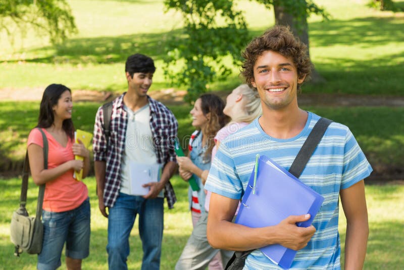 Portrait of a boy with happy college friends in background at the campus. Portrait of a boy with happy college friends in background at the campus