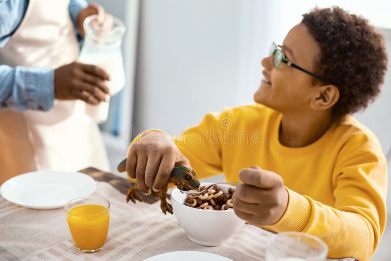 Garçon avec du charme causant avec le père tout en jouant pendant le petit déjeuner photos libres de droits Garçon avec du charme causant avec le père tout en jouant pendant le petit déjeuner photos libres de droits