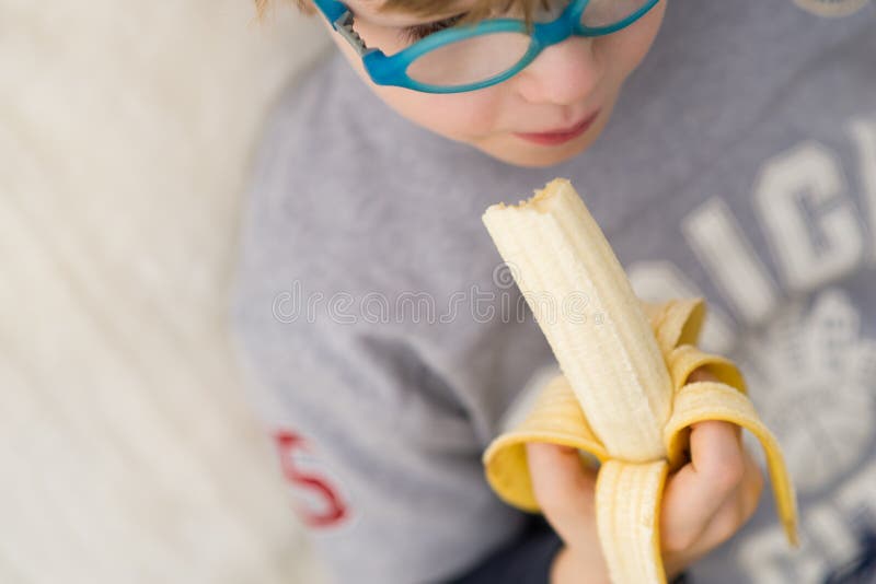Garçon avec la banane - enfant mangeant la banane image libre de droits Garçon avec la banane - enfant mangeant la banane image libre de droits