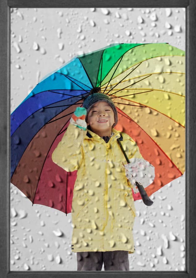 Garçon avec le parapluie sous la pluie d'hiver photo stock Garçon avec le parapluie sous la pluie d'hiver photo stock