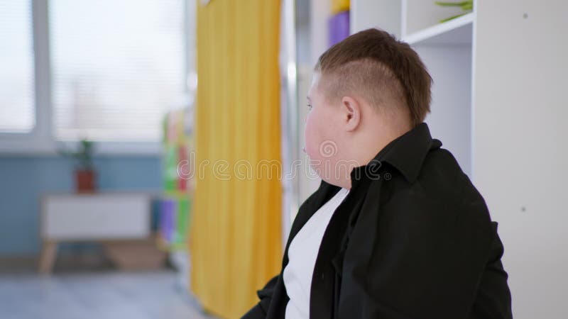 Garçon avec le syndrome du bas pendant une leçon dans une école inclusive banque de vidéos