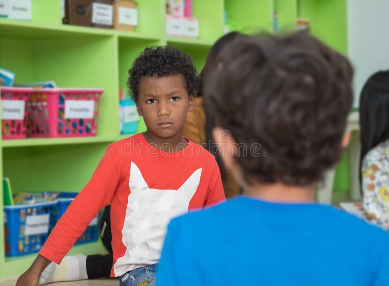 African american boy angry and looking at friend in school library in kindergarten.kids education concept. African american boy angry and looking at friend in school library in kindergarten.kids education concept