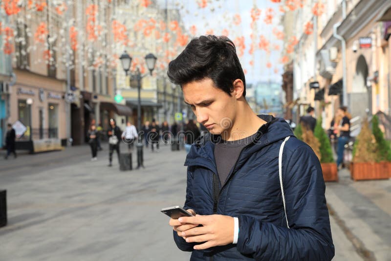 Garçon d'étudiant employant la tablette numérique ou le phone futé mobile photographie stock