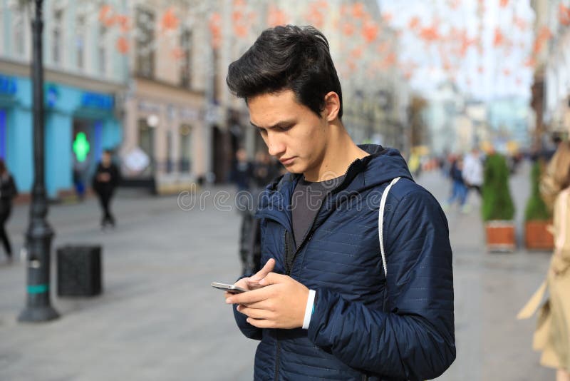 Garçon d'étudiant employant la tablette numérique ou le phone futé mobile photos libres de droits