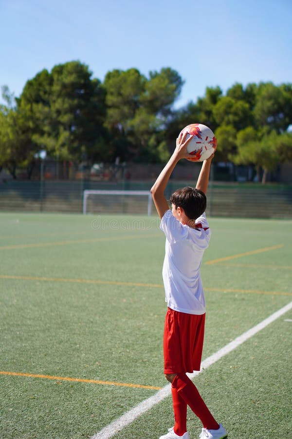 Garçon de préadolescence jouant à un match de football en prenant un gorge image stock