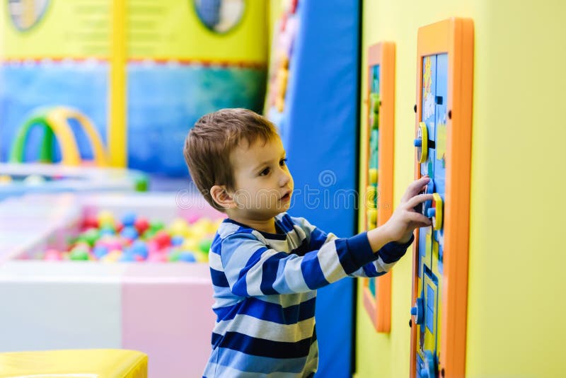 Garçon heureux ayant l'amusement dans le puits de boule au parc d'attractions d'enfants et au centre d'intérieur de jeu Enfant jo photographie stock libre de droits Garçon heureux ayant l'amusement dans le puits de boule au parc d'attractions d'enfants et au centre d'intérieur de jeu Enfant jo photographie stock libre de droits