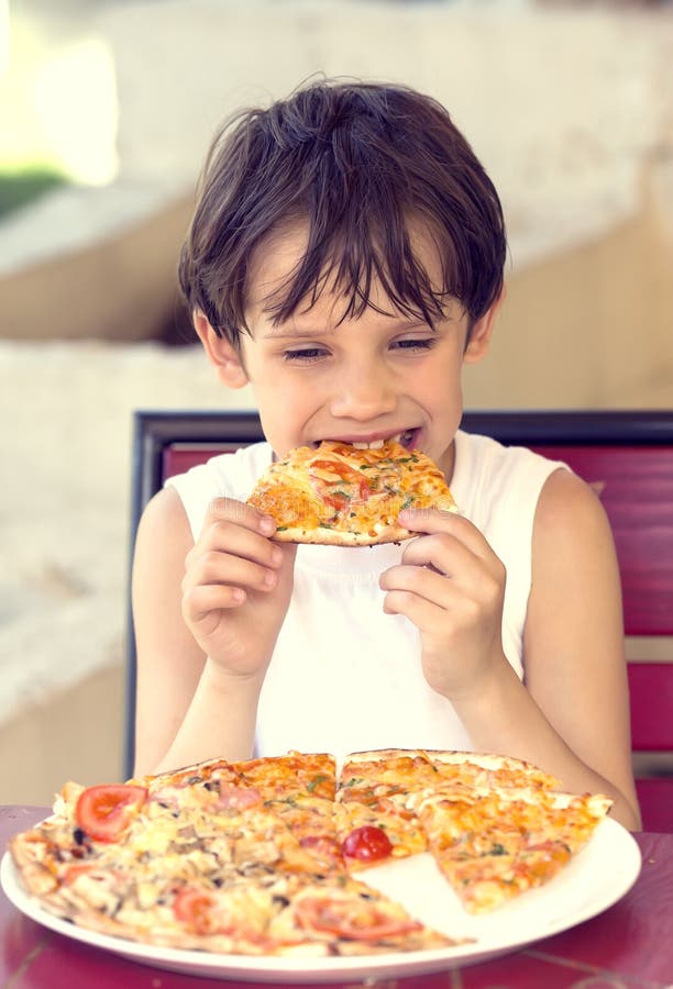 garçon mangeant de la pizza images libres de droits garçon mangeant de la pizza images libres de droits