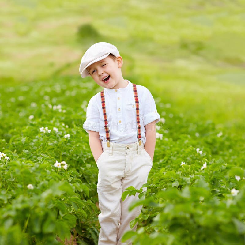 Garçon mignon d'agriculteur se tenant dans des rangées de pommes de terre photos libres de droits Garçon mignon d'agriculteur se tenant dans des rangées de pommes de terre photos libres de droits