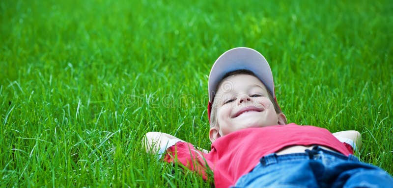 Garçon s'étendant sur l'herbe. Stationnement de pique-nique de famille au printemps photos libres de droits Garçon s'étendant sur l'herbe. Stationnement de pique-nique de famille au printemps photos libres de droits