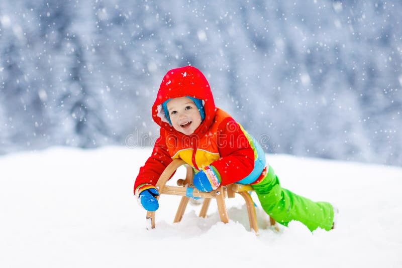 Garçon sur le tour de traîneau Sledding d'enfant Enfant sur le traîneau photos stock Garçon sur le tour de traîneau Sledding d'enfant Enfant sur le traîneau photos stock