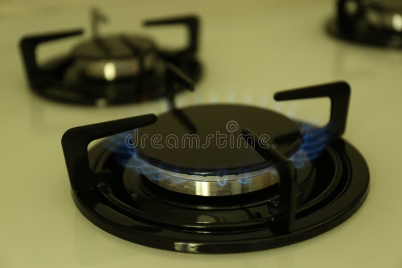 Gas Burner of Modern Stove with Burning Blue Flame, Closeup Stock Photo