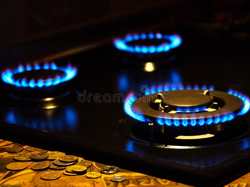 Gas Flames of Three Gas Burners on Dark Background with Coins on the
